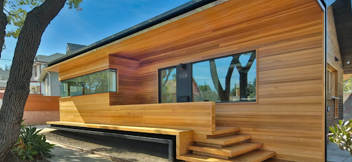 This home has cedar siding. There are long, rectangular windows on the home.